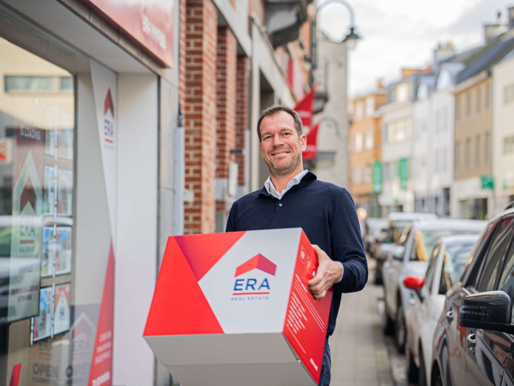 Een man draagt een ERA verhuisdoos.