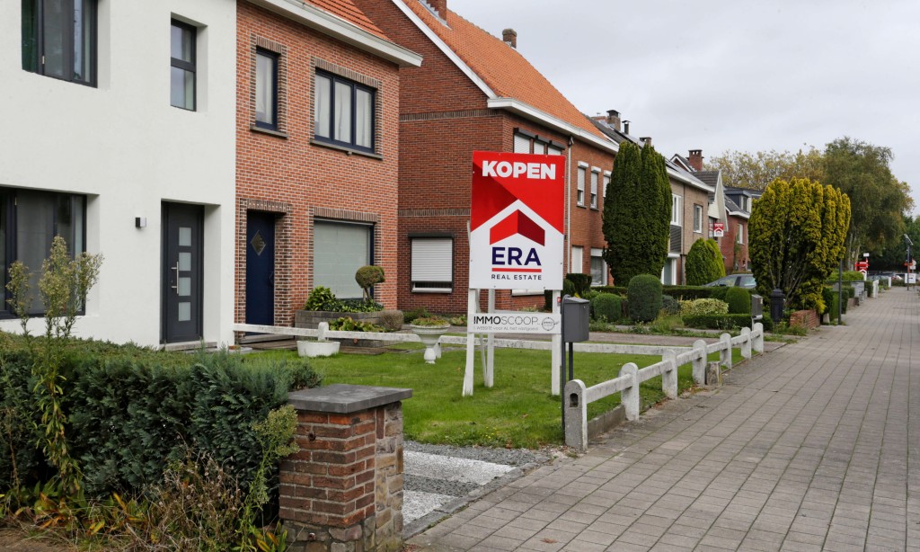 Er staat een groot rood V-bord in de voortuin van een woning dat verkocht wordt via ERA.